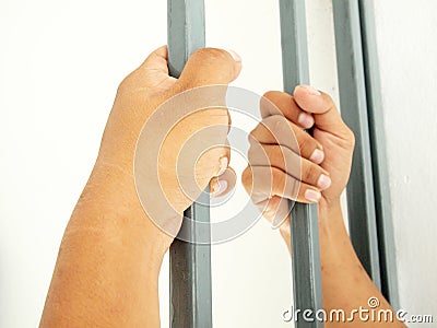 Hands clutching bars Stock Photo