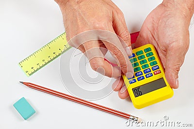 Hands compute using a digital calculator over workplace of the engineer Stock Photo