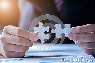 Hands connecting jigsaw puzzle. Business solutions, success and strategy concept. Close up photo with selective focus Stock Photo