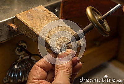 Hands of a craftsman jeweler working on jewelry. Goldsmith. Jewelry and valuables workshop. Goldsmith Hand Drill. Stock Photo
