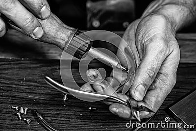 Hands of an craftsman working with the metal tongs Stock Photo