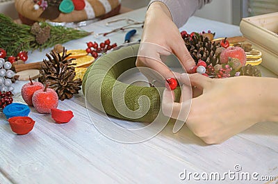 Hands creating Christmas wreath and ribbon bow on a wooden board Stock Photo