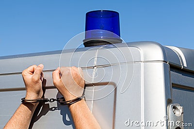 Hands of criminals in handcuffs based on a police car. Stock Photo