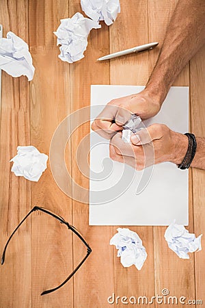 Hands crumpling paper on wooden desk Stock Photo