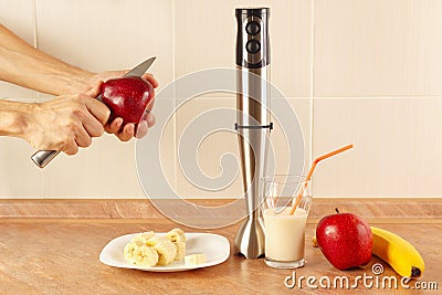 Hands cut apple to prepare the cocktail on table Stock Photo
