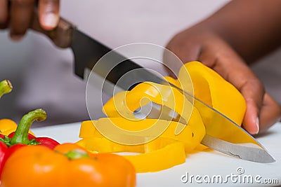 Hands cutting bell peppers with knife, food preparation Stock Photo