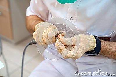 Hands dentist adjust the size of the denture. Stock Photo