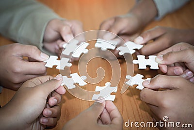 Hands of diverse people assembling jigsaw puzzle, Youth team put pieces together searching for right match, help support in Stock Photo