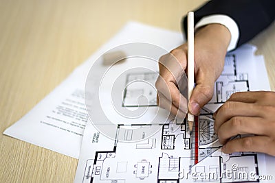 Hands Drawing House Plan on Desk Stock Photo