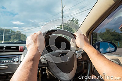 Hands driving a car in home town, safety drive and car insurance concept Stock Photo