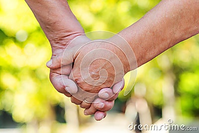 Hands of an elderly couple, close-up. Olderly couple holding hands during walking. Love concept Stock Photo