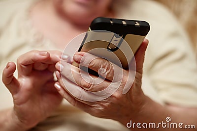 Hands of an elderly woman holding a mobile phone Stock Photo