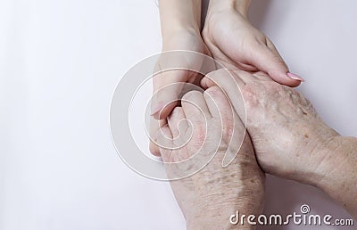 Hands of an elderly woman in the hands of a young woman caring for old age Stock Photo