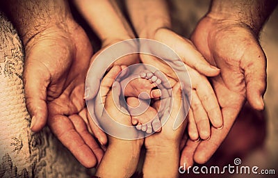 Hands of father, mother, daughter keep little feet baby. Friendly happy family Stock Photo