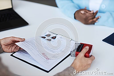 Hands of female manager of visa application center putting rejected stamp Stock Photo