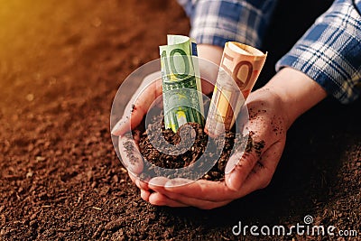 Hands with fertile soil and euro money banknotes Stock Photo