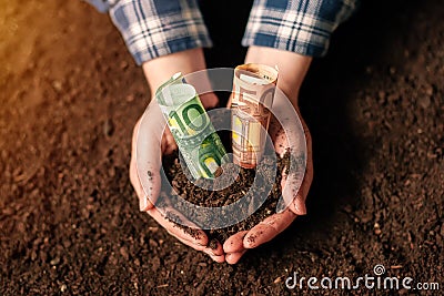 Hands with fertile soil and euro money banknotes Stock Photo