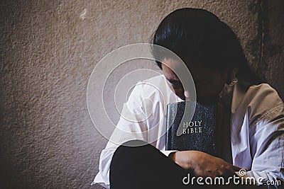 Hands folded in prayer on a Holy Bible in church concept for faith Stock Photo