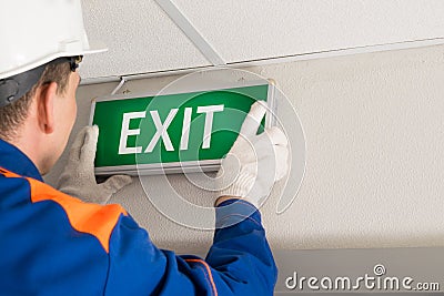 The hands of the foreman install emergency exit lighting Stock Photo