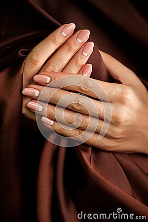 Hands with french-style manicure wrapped with silk Stock Photo