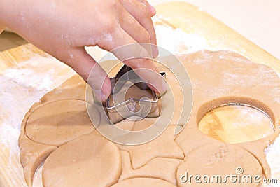 Hands of a girl with dough cooking cookies on a wooden table . Close up Stock Photo