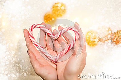 Hands holding a heart made of a christmas candy Stock Photo