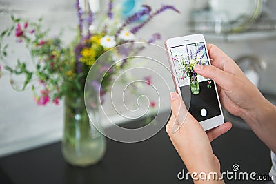 Hands of a girl photographing a bouquet of flowers Stock Photo