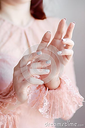 Hands of a girl in a pink lace dress with frills on a white background raised up Stock Photo