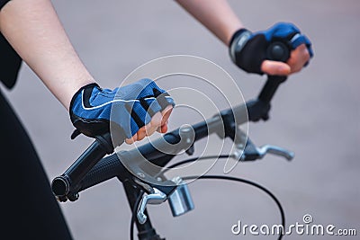 Hands of a girl in a sports blue-black gloves holding on to the Stock Photo