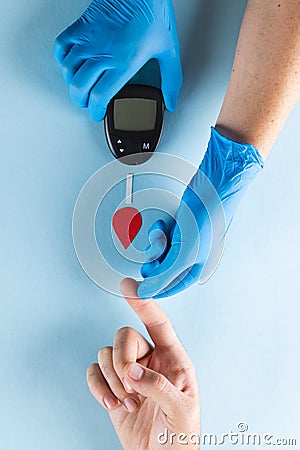 Hands of gloved doctor with glucometer taking blood sugar reading from caucasian woman Stock Photo