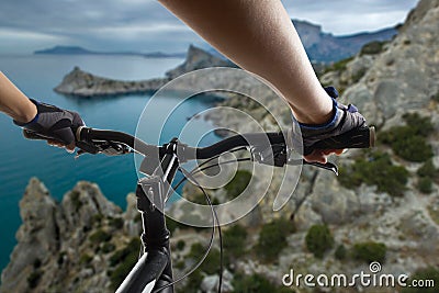 Hands in gloves holding handlebar of a bicycle. Mountain Bike cyclist riding single track. Healthy lifestyle active athlete doing Stock Photo