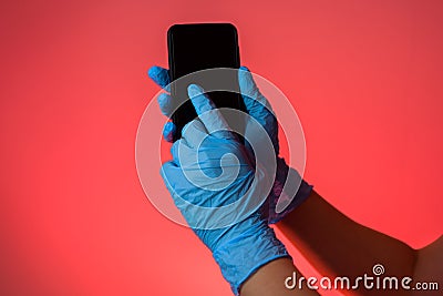 Hands in the gloves touching scren on the smartphone Stock Photo