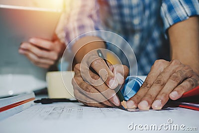 Hands of group engineer and architect working on blueprint and mobile tablet on workplace desk Stock Photo