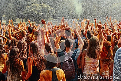 Hands and happy people crowd partying under rain at holi fest, f Editorial Stock Photo