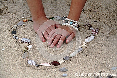 Hands in the heart in the sand. Stock Photo