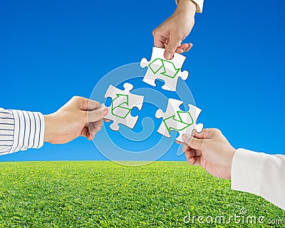 Hands hold puzzles with recycle symbol and beautiful landscape g Stock Photo