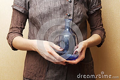 Hands holding blue bottle Stock Photo