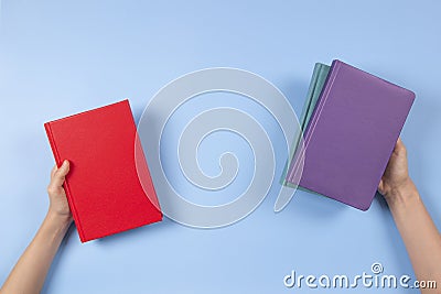 Hands holding books over light blue background. Education, self-learning, book swap, sharing, bookcrossing concept Stock Photo