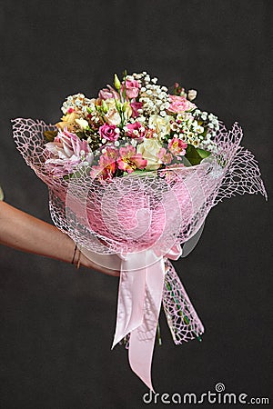 Florist holding a buquet of various flowers on the dark background Stock Photo