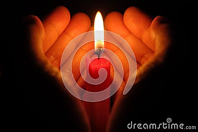 Hands holding a burning candle Stock Photo