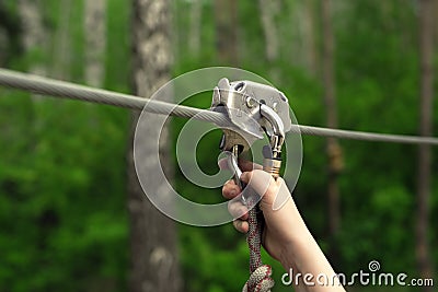 Hands holding carabiner on zip line Stock Photo