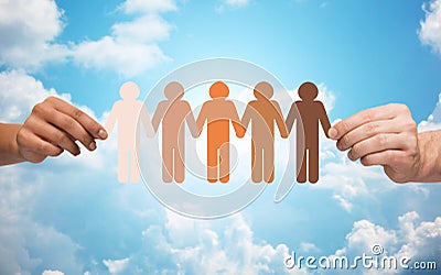 Hands holding chain of people pictogram over sky Stock Photo