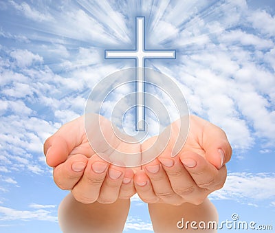 Hands holding Christian cross with light beams Stock Photo