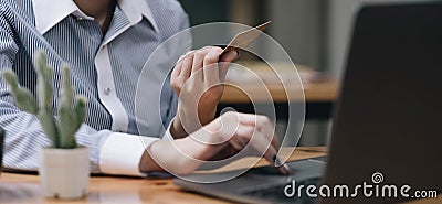 Hands holding credit card, typing on the keyboard of laptop, onine shopping detail close up Stock Photo