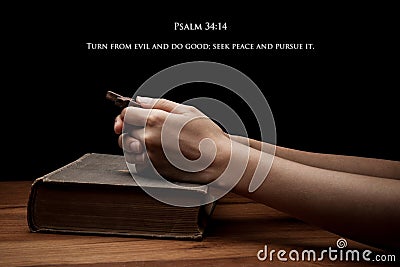 Hands holding a cross on holy Bible with verse Stock Photo