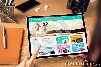 Hands holding digital tablet with application booking flight travel search ticket holiday and hotel on website discounted price. Stock Photo