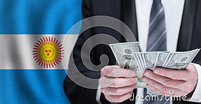 Hands holding dollar money on flag of Argentina Stock Photo