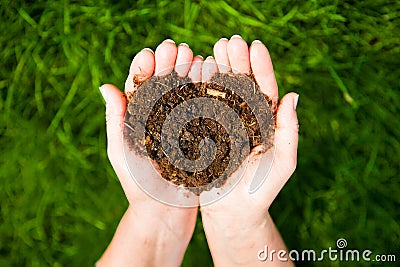 Hands holding an earth heart on natural green background. Ecolog Stock Photo