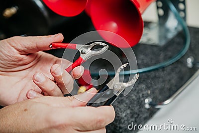 Hands holding electrical clips red and black Stock Photo