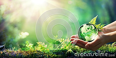 Hands Holding Globe Glass In Green Forest Stock Photo